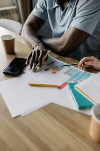 Two business professionals collaborating on a colorful project plan indoors.